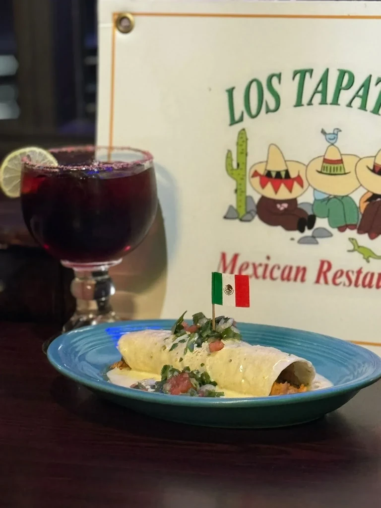 A burrito with pico de gallo and a margarita at a Mexican restaurant.