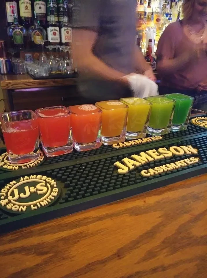 Seven colorful shots on a Jameson branded bar mat.