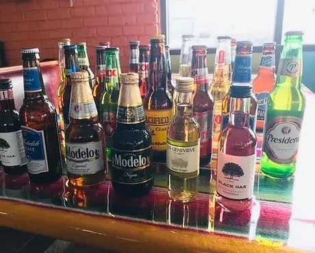 Assorted beer and liquor bottles on a colorful serape.