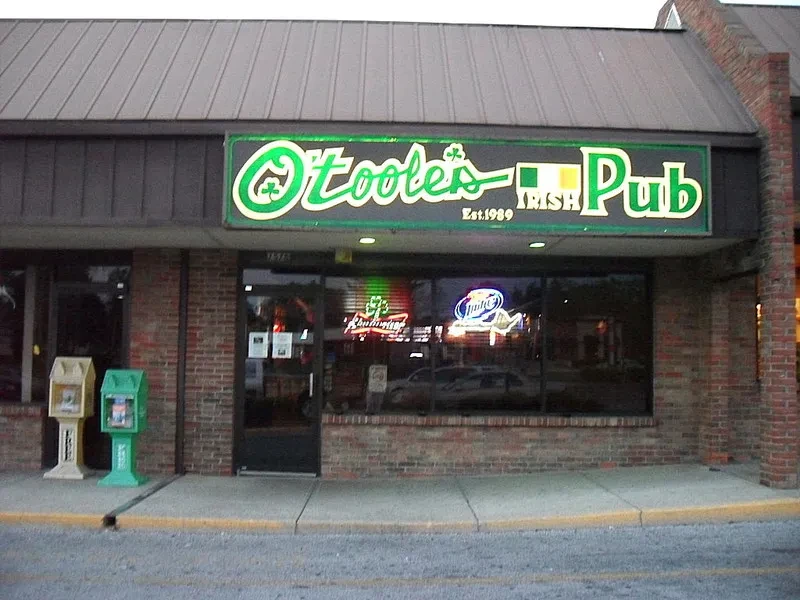 Exterior of O'Toole's Irish Pub with green neon sign at dusk.
