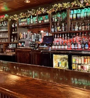 Festive, well-stocked bar with liquor bottles and beer taps.
