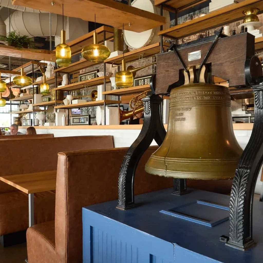 Ornate bronze bell in restaurant, surrounded by Ohio-themed decor.