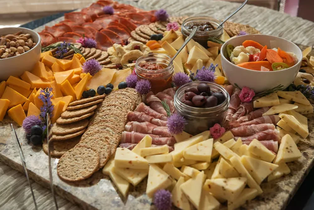 An expansive charcuterie and cheese board with meats, cheeses, and diverse accompaniments.