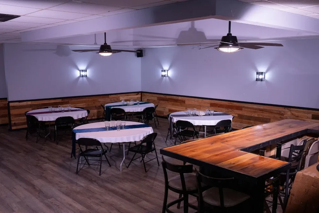 Empty restaurant interior with set tables and a rustic wooden bar.