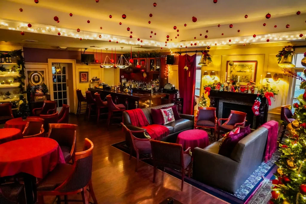Christmas-decorated bar and lounge with red furnishings and warm lighting.