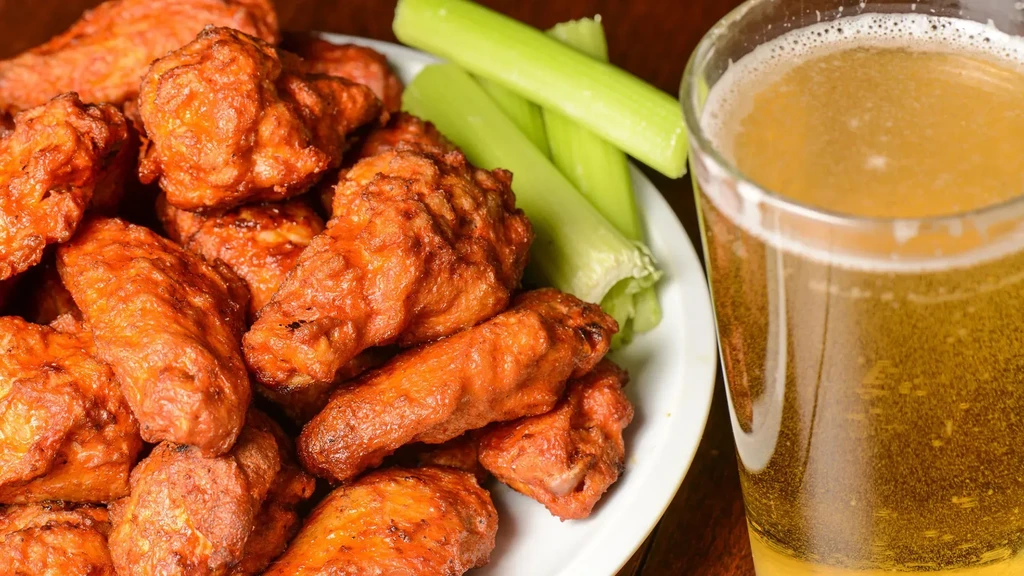 Piled buffalo wings, celery, and a mug of foamy beer.