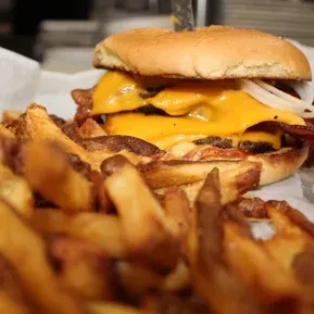 Double cheeseburger with melted cheese, bacon, onions, and golden fries.