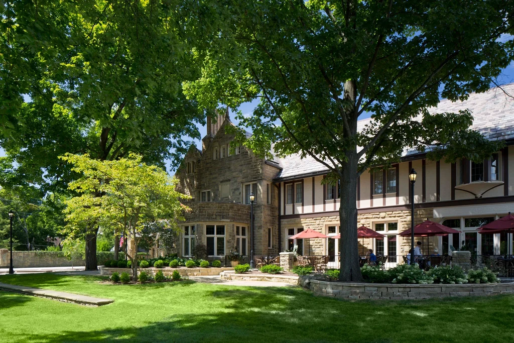 Grand stone building, outdoor patio with vibrant red umbrellas.