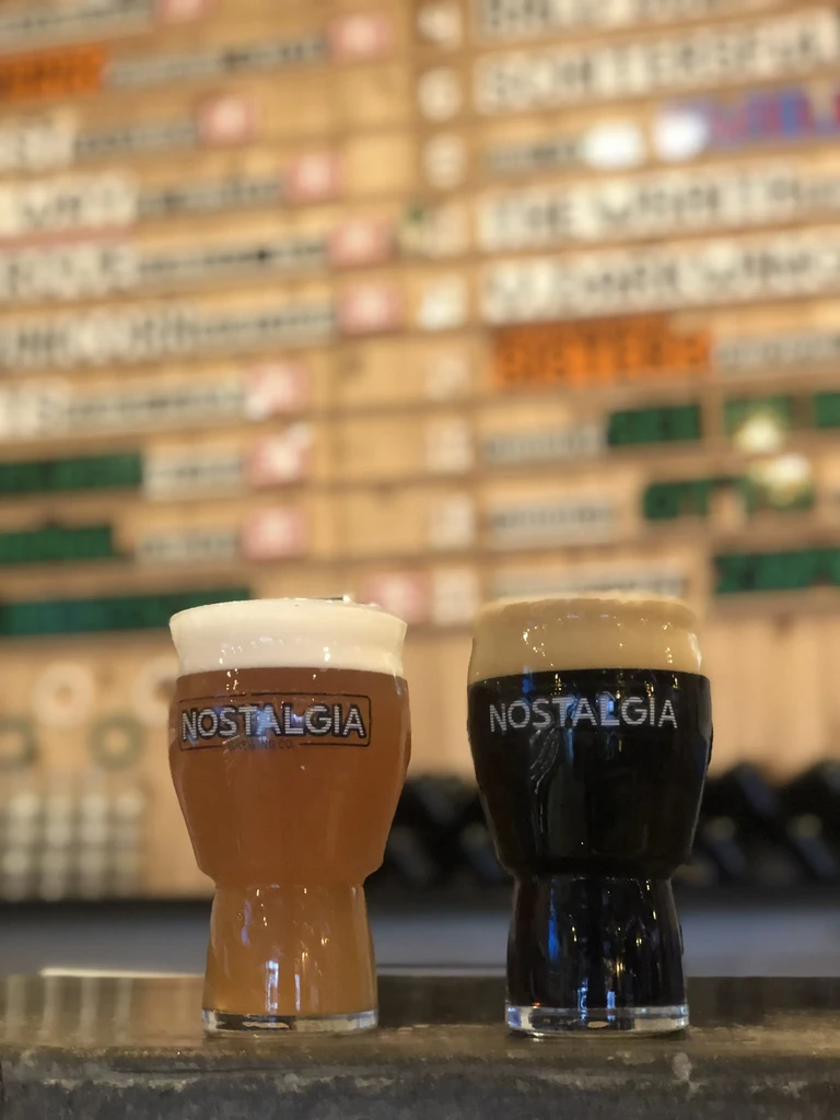 Two Nostalgia beers, amber and dark, on a stone counter.