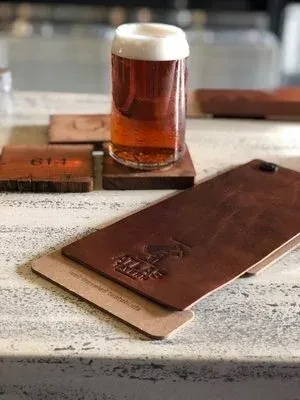 Close-up: Beer with foam, coasters, Atlas Tavern menu.