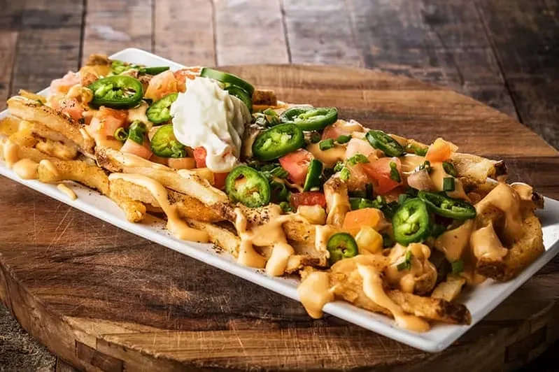 Loaded french fries with cheese sauce, jalapeños, tomatoes, and sour cream.