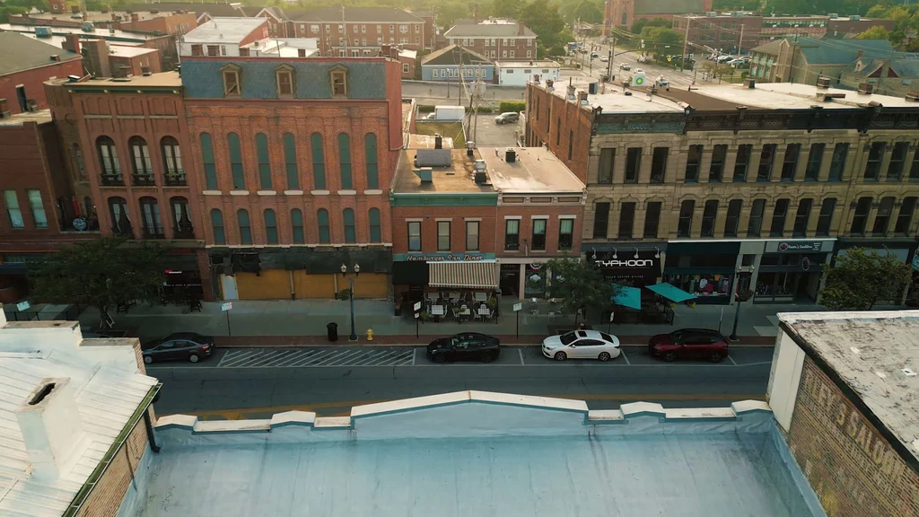 High-angle view of a bustling historic street with brick buildings and diners.