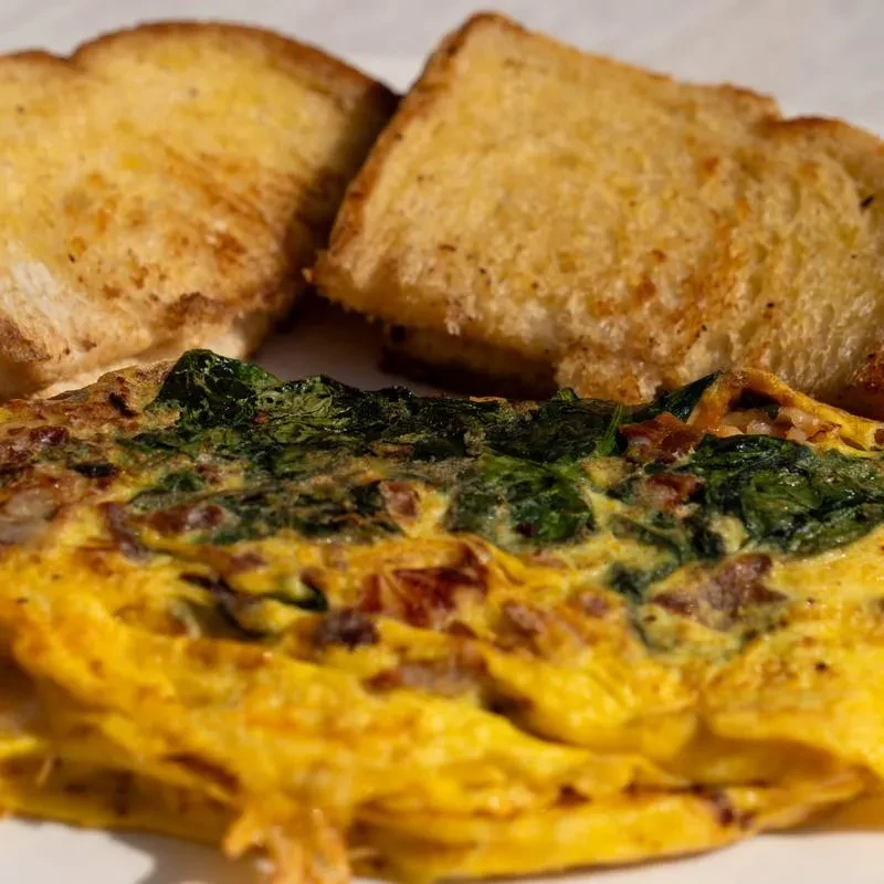 Spinach omelet and two upright slices of toasted bread.
