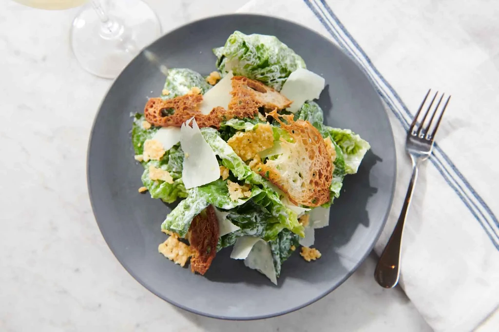 Crisp Caesar salad with rustic croutons and Parmesan on a plate.