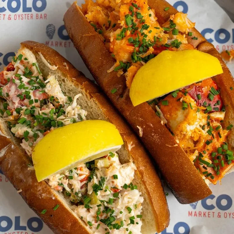 Two lobster rolls: one creamy, one warm, with chives and lemon.