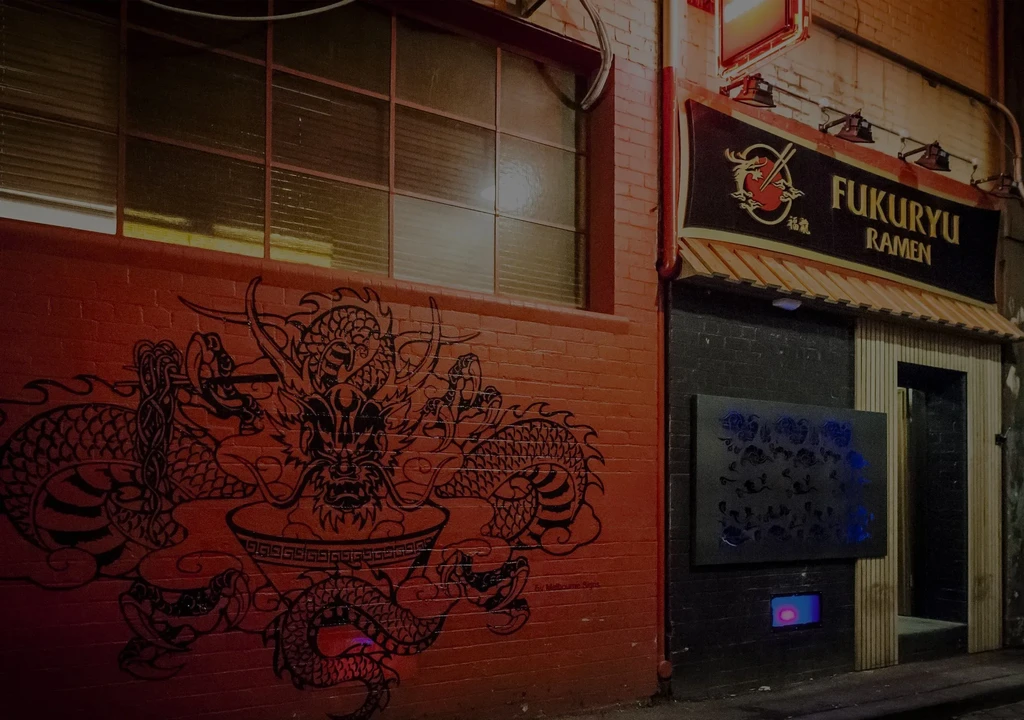 Nighttime exterior of Fukuryu Ramen with a large dragon mural.