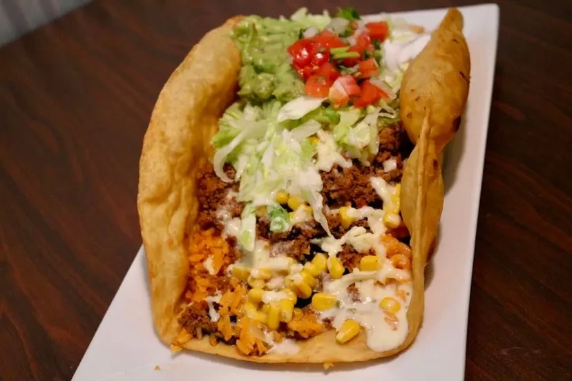 Deep-fried tortilla bowl with meat, lettuce, guacamole, and pico.
