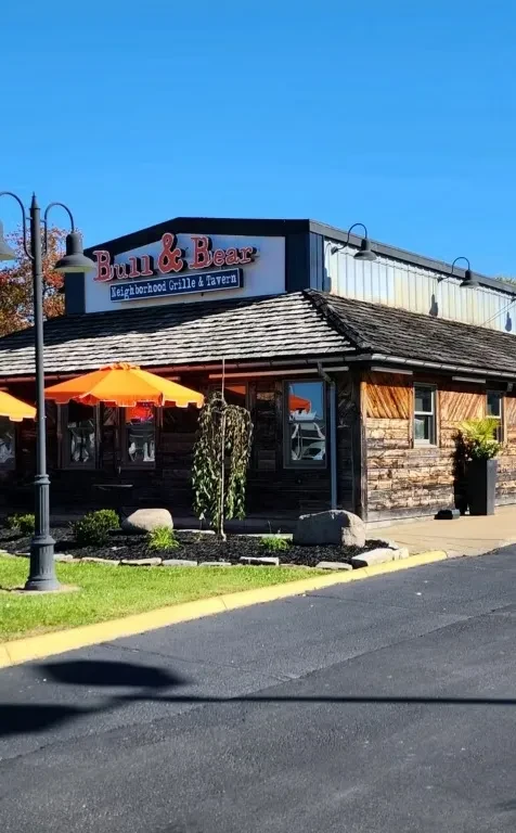 Bull & Bear Grille & Tavern's rustic-modern exterior, landscaping, sunny day.