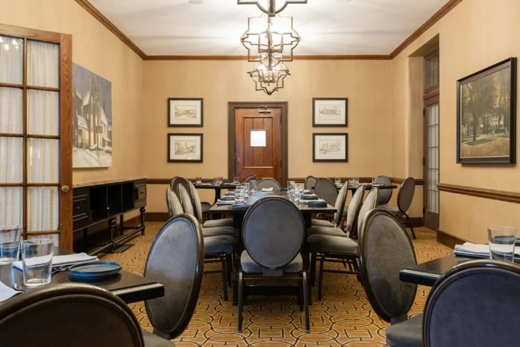 Meticulously set private dining room with art and ornate chandelier.