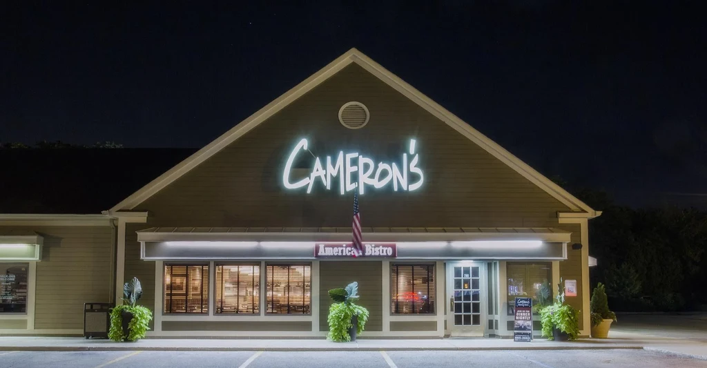 Cameron's American Bistro exterior at night with glowing neon sign.