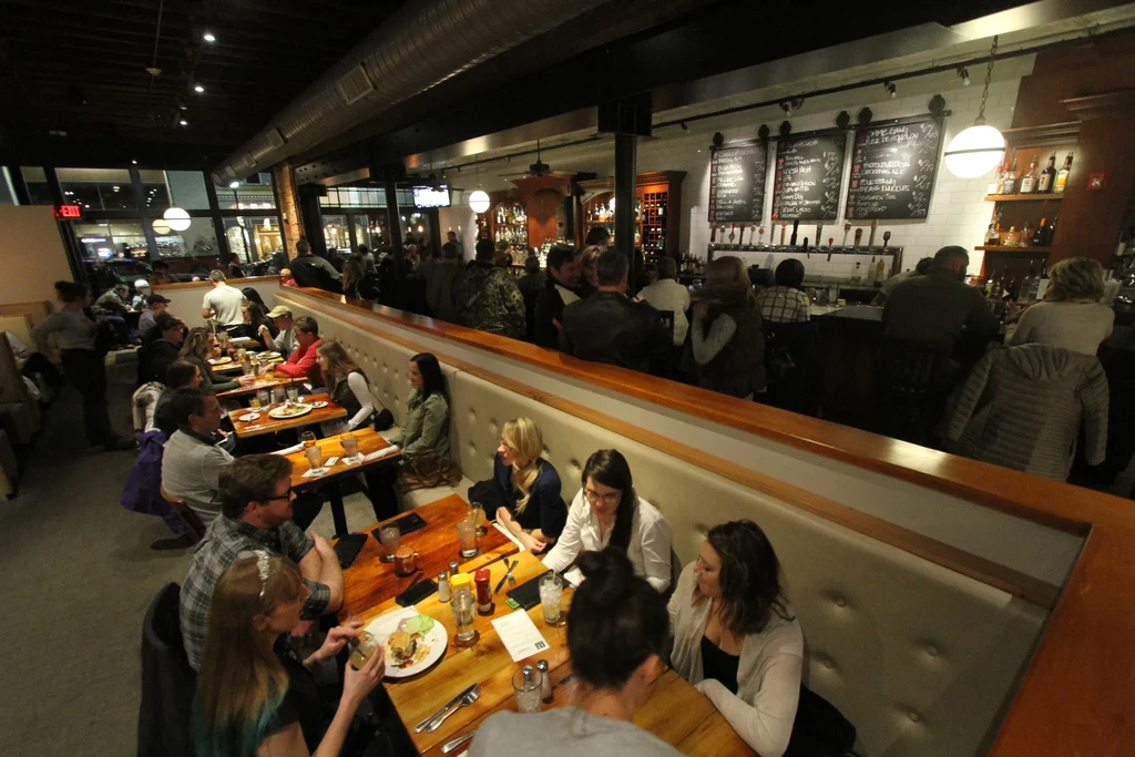 Vibrant, industrial-chic restaurant and bar bustling with patrons.