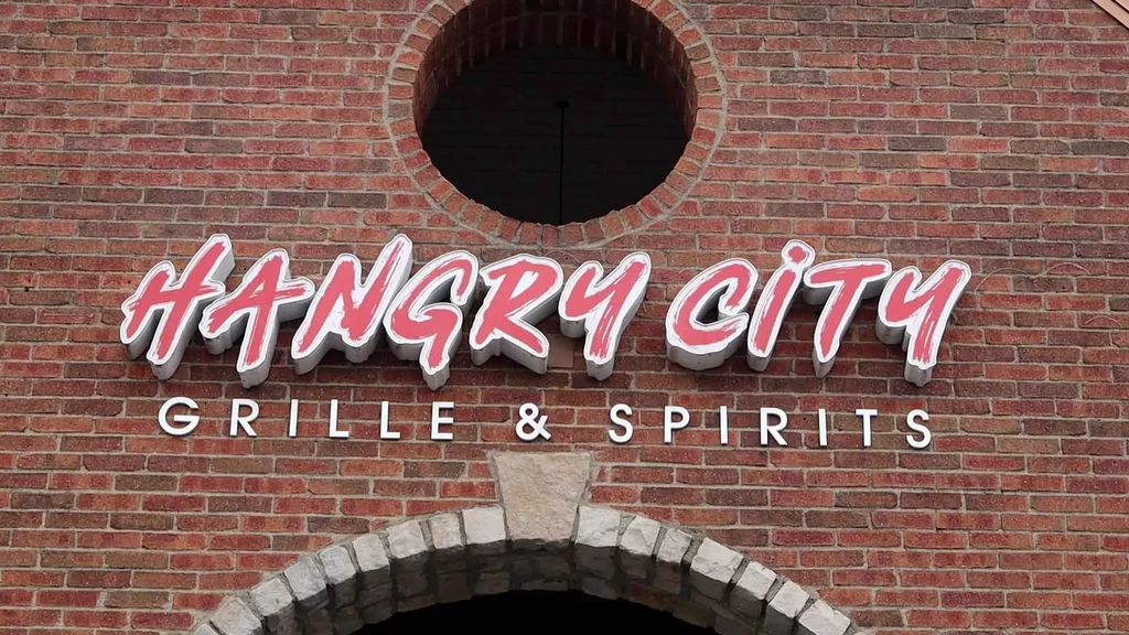 Hangry City Grille & Spirits sign on a red brick wall.