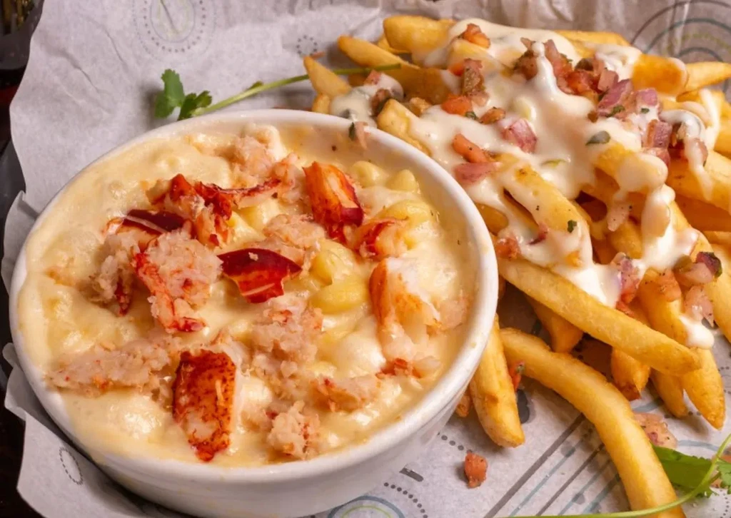 Lobster macaroni and cheese next to cheesy fries with bacon.