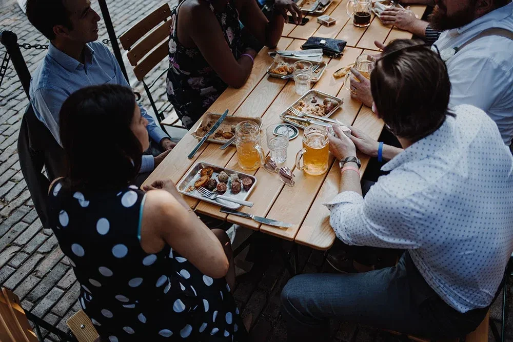 Overhead view of people enjoying food and drinks outdoors.