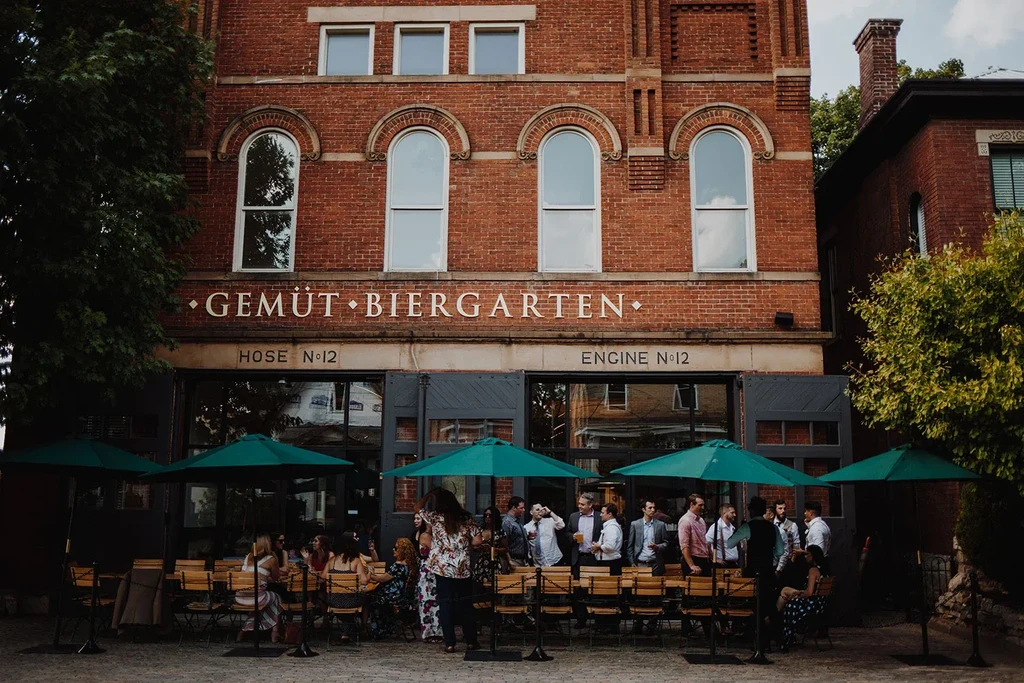 Gemüt Biergarten, former fire station, with outdoor patio and people.