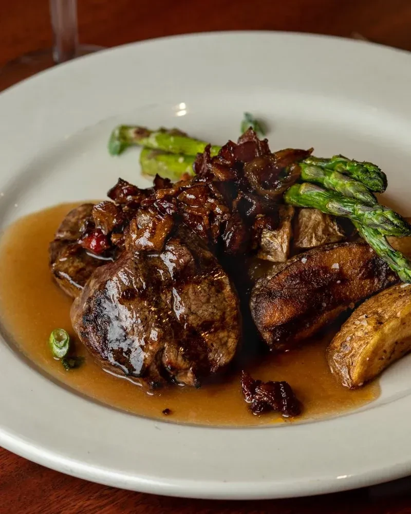 Seared beef medallions, caramelized onions, roasted potatoes, and asparagus with gravy.
