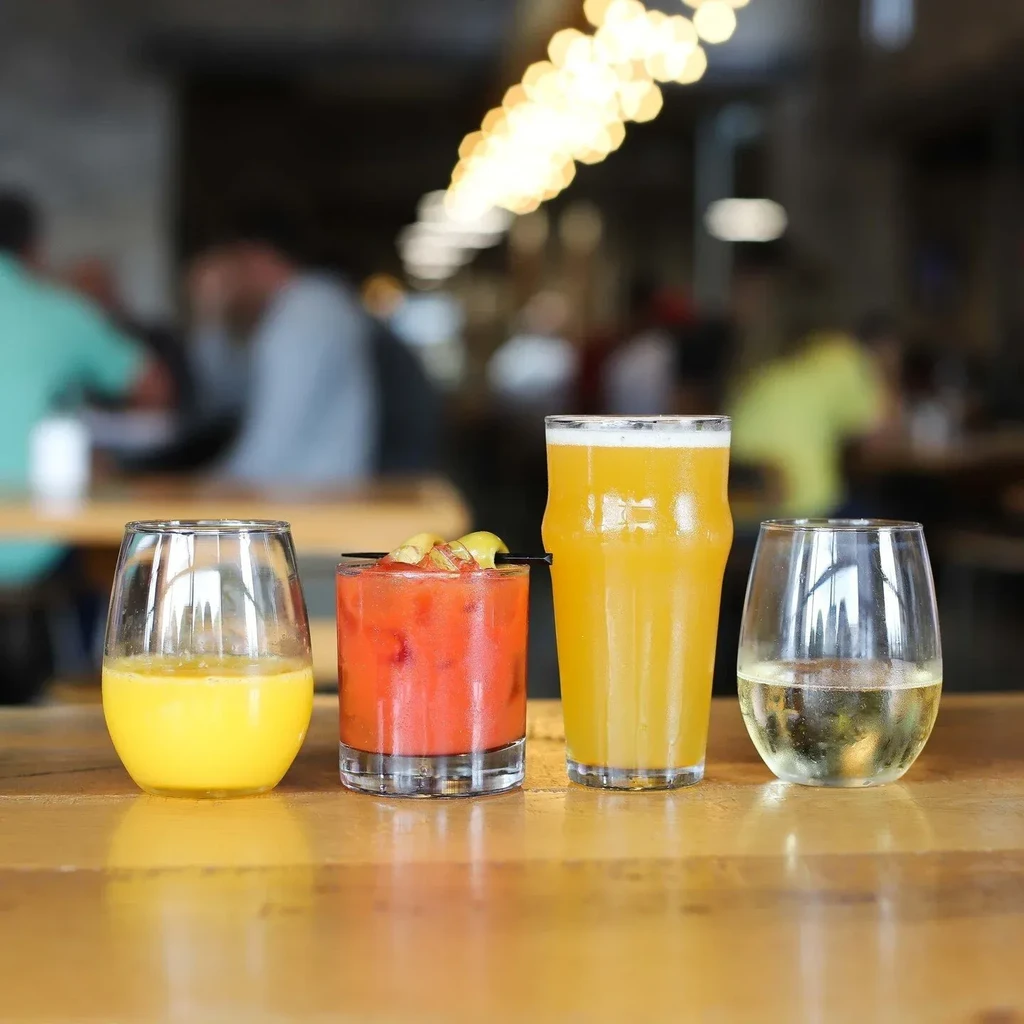 Four distinct drinks, including beer and wine, on a restaurant table.
