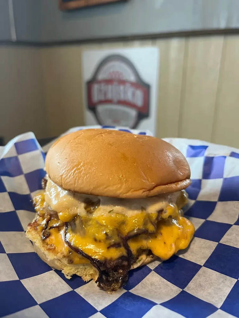 Gourmet multi-patty burger with melted cheese and caramelized onions.