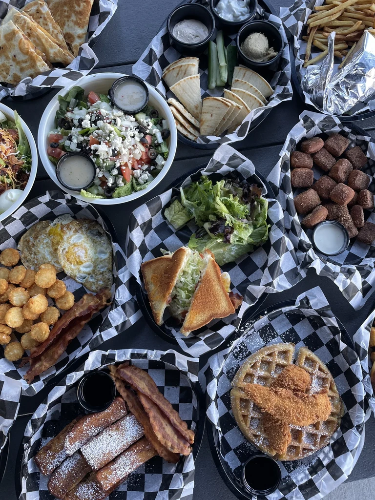 Overhead shot of a table laden with various casual dishes in baskets.