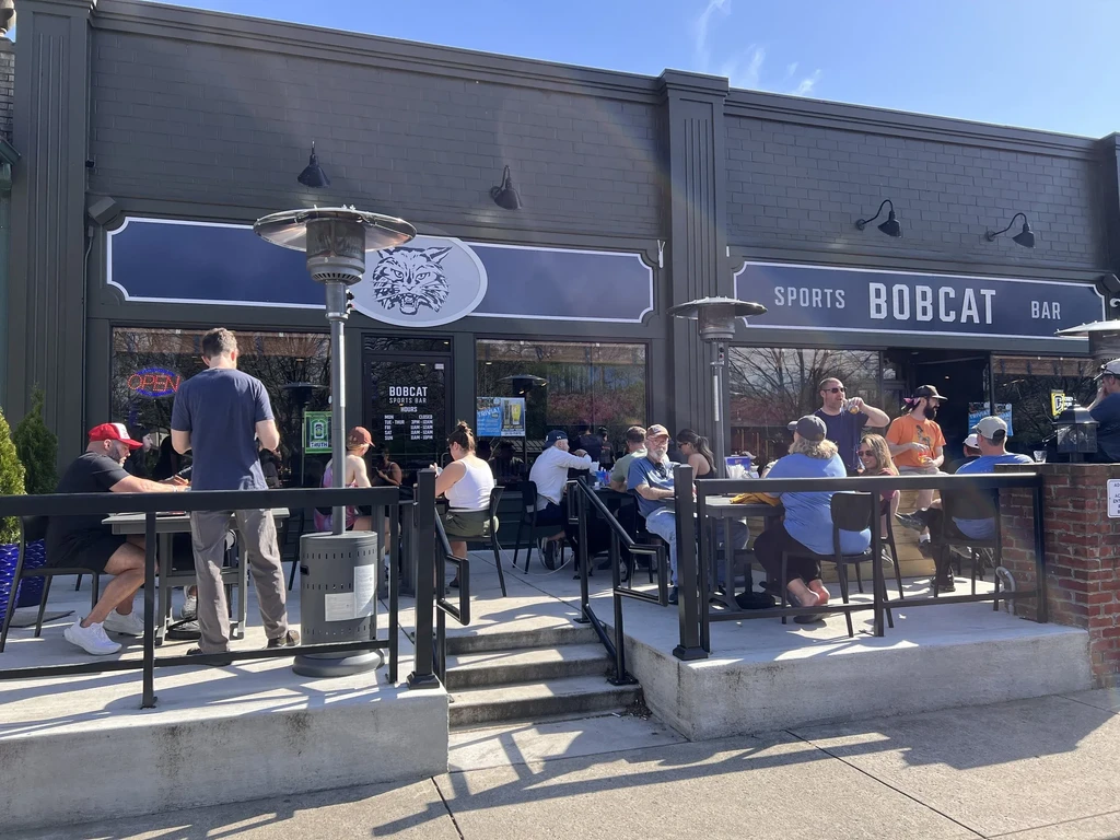 Bobcat Sports Bar patio filled with patrons enjoying a sunny day.