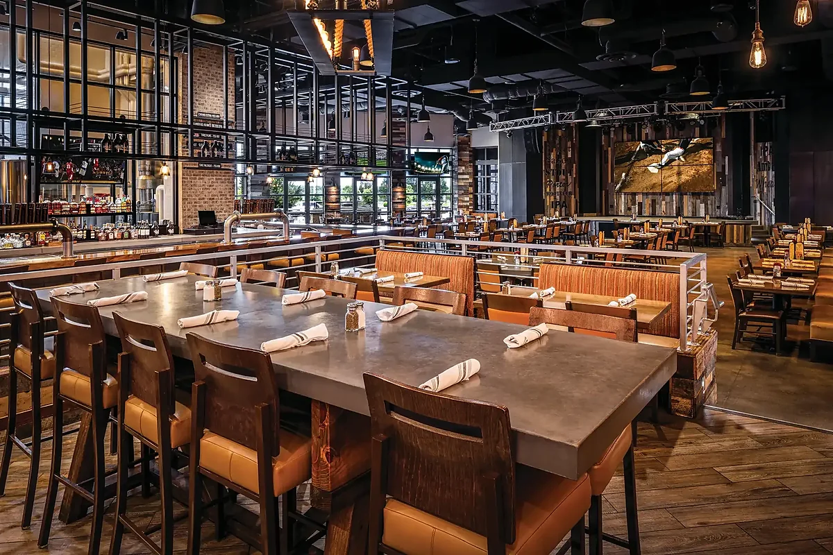Dining room with communal table, booths and industrial pendant lighting