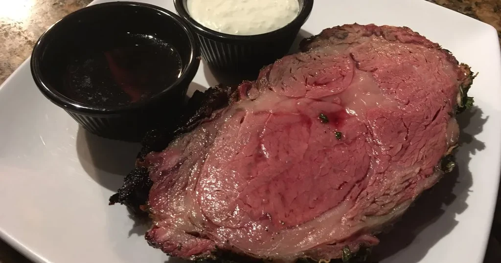 Medium-rare roast slice with au jus and creamy sauce.