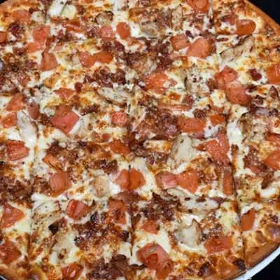 Sliced pizza with melted cheese, tomatoes, chicken, and savory bits.