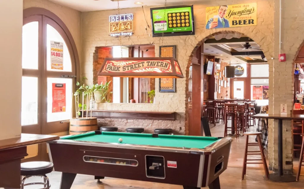 Interior of Park Street Tavern with pool table and brewery signs.