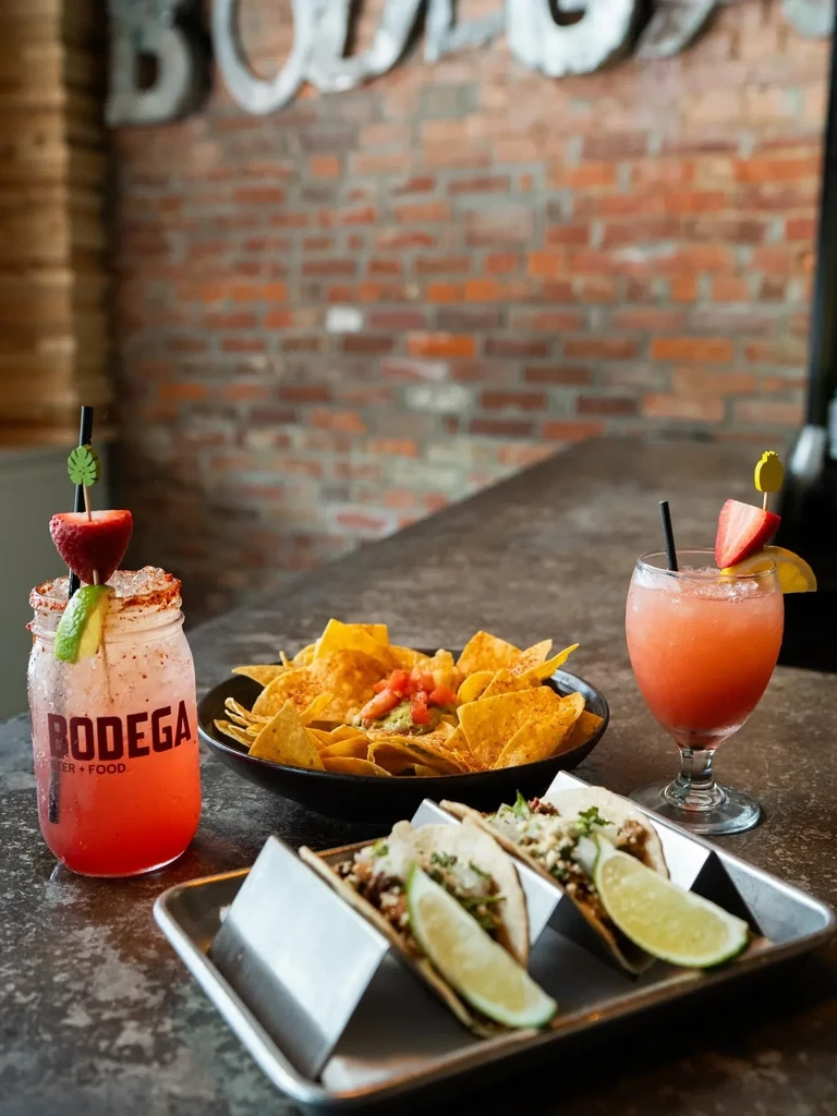 Tacos, guacamole, chips, and cocktails on a counter at Bodega.