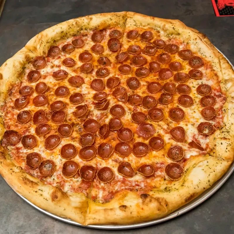 Pepperoni pizza with melted mozzarella and curled pepperoni on a silver pan.