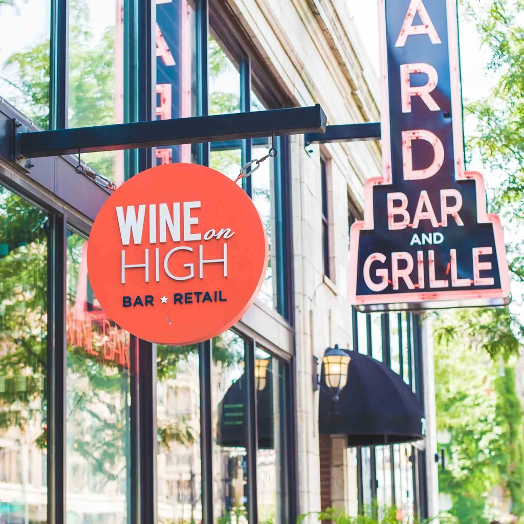 Orange 'WINE on HIGH' and neon 'ARD BAR AND GRILLE' signs.