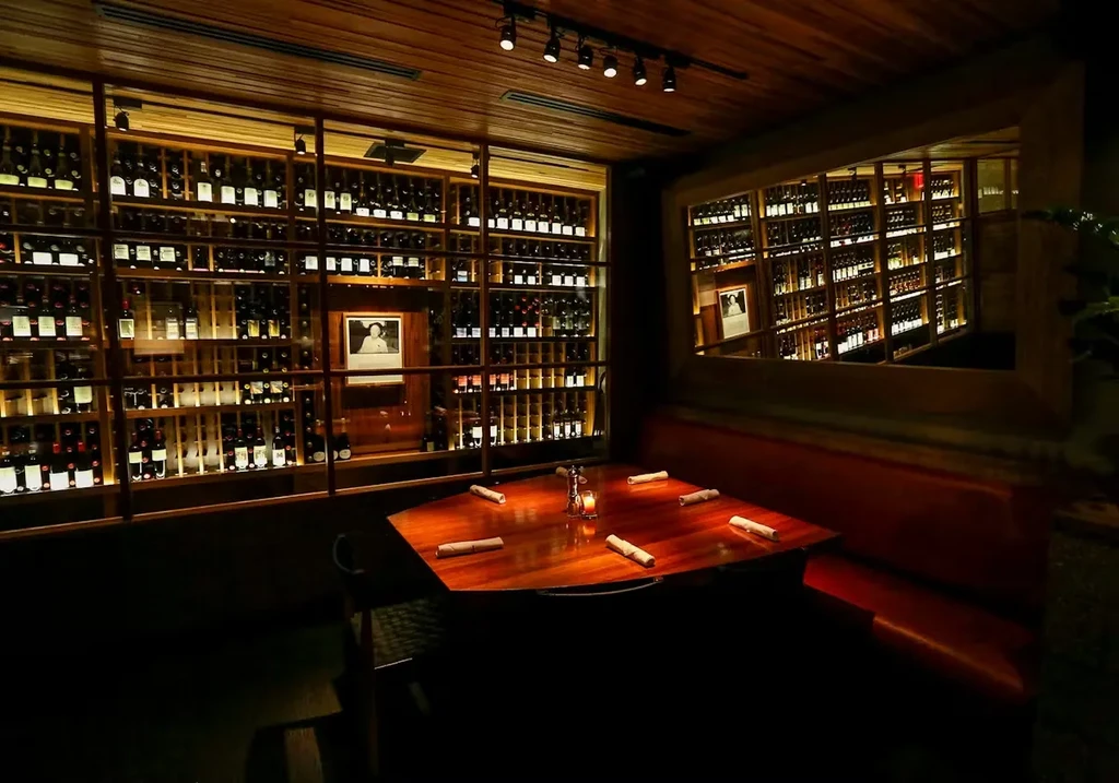 Upscale restaurant interior: prominent wine wall, set table.