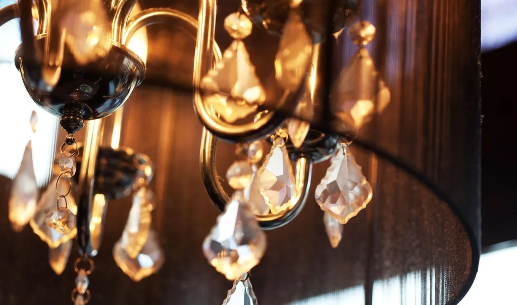 Elaborate chandelier with faceted crystal pendants and curved metallic arms.