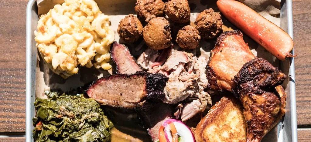 Close-up: BBQ platter with brisket, pulled pork, chicken, and sides.