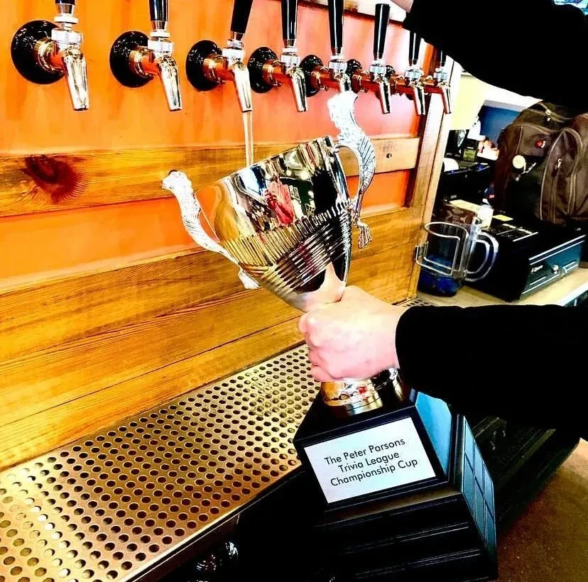 The Peter Parsons Trivia League Championship Cup being filled with beer.