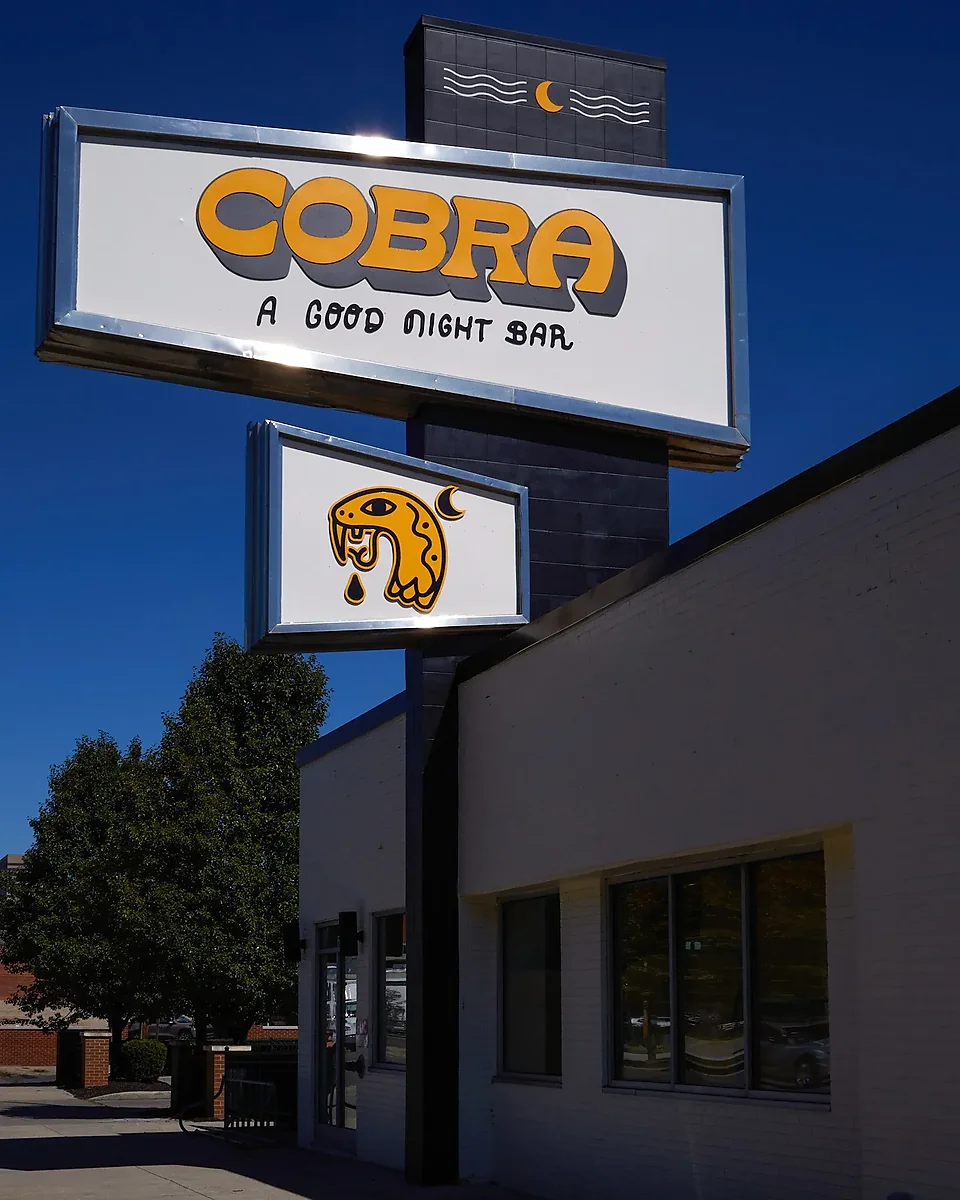Exterior of Cobra bar with yellow sign under blue sky