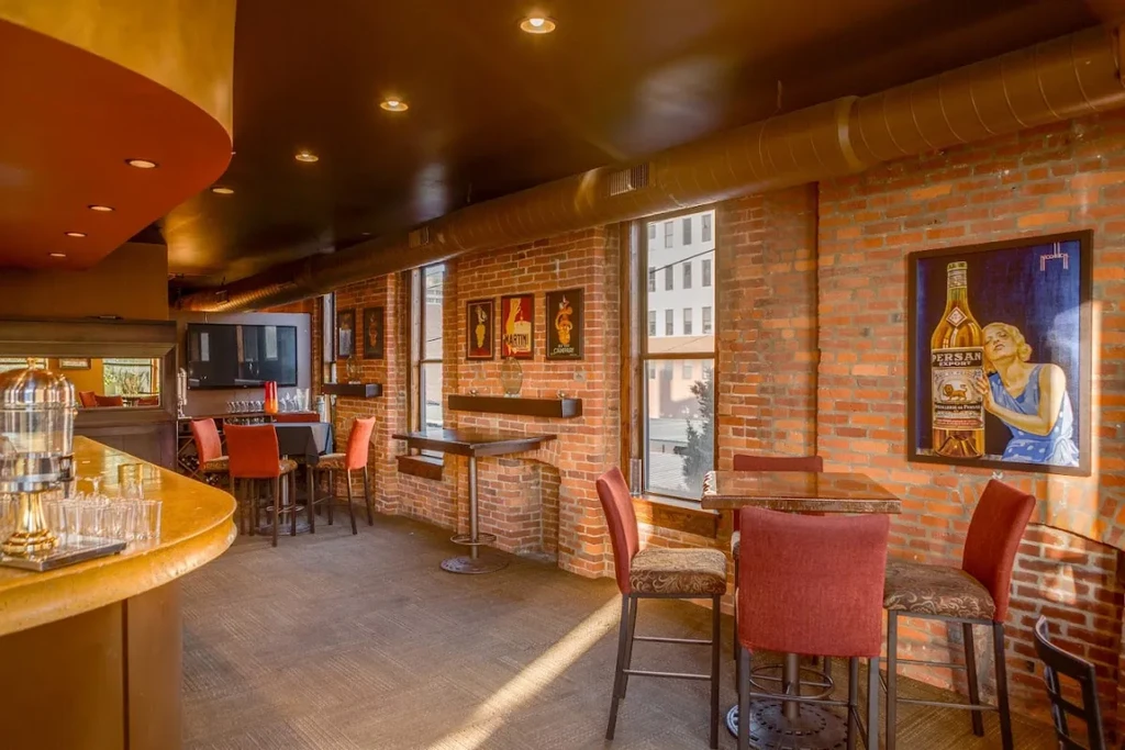 Modern-industrial interior: red brick walls, wooden bar, vintage art.
