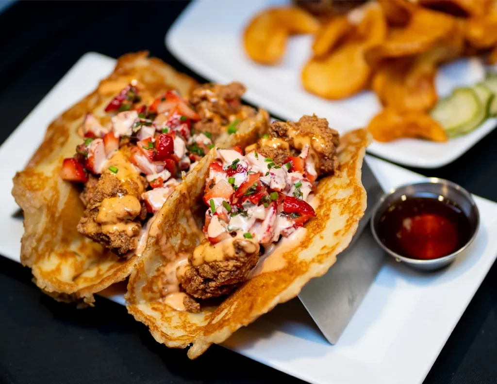 Crispy fried chicken tacos in pancakes, topped with strawberry salsa.