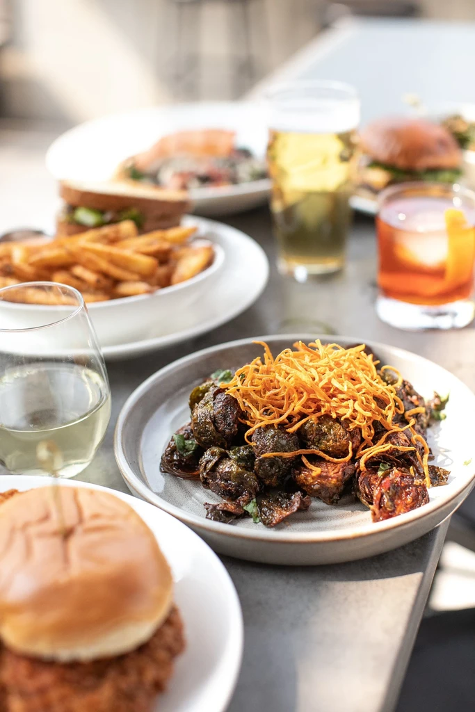 Brussels sprouts, wine, beer, and other food items on a table.
