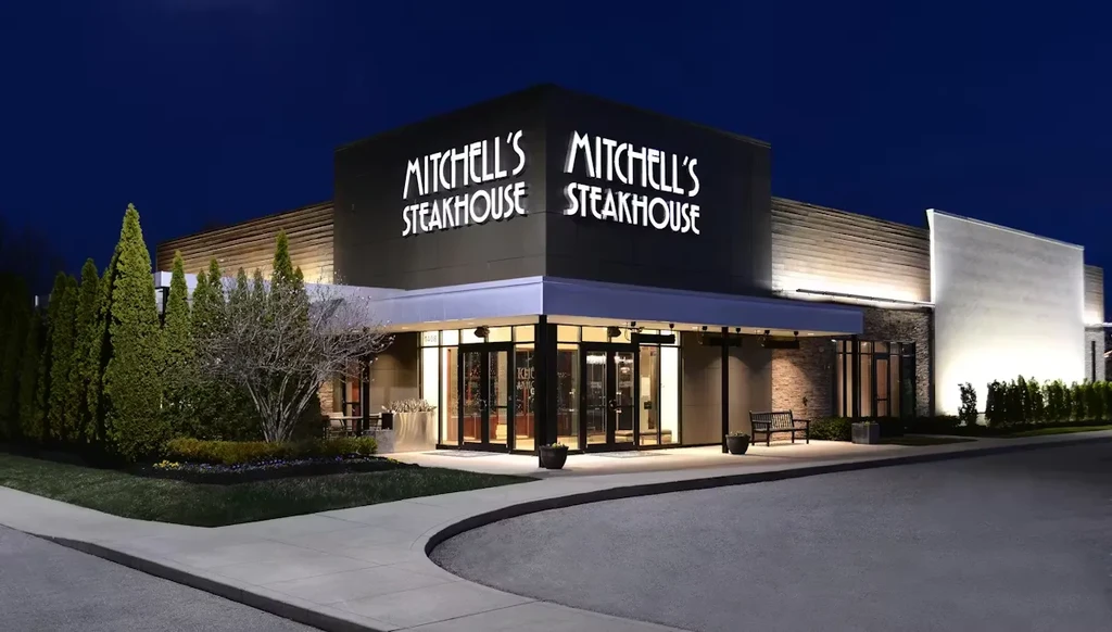 Modern Mitchell's Steakhouse exterior at night, with illuminated sign and entrance.